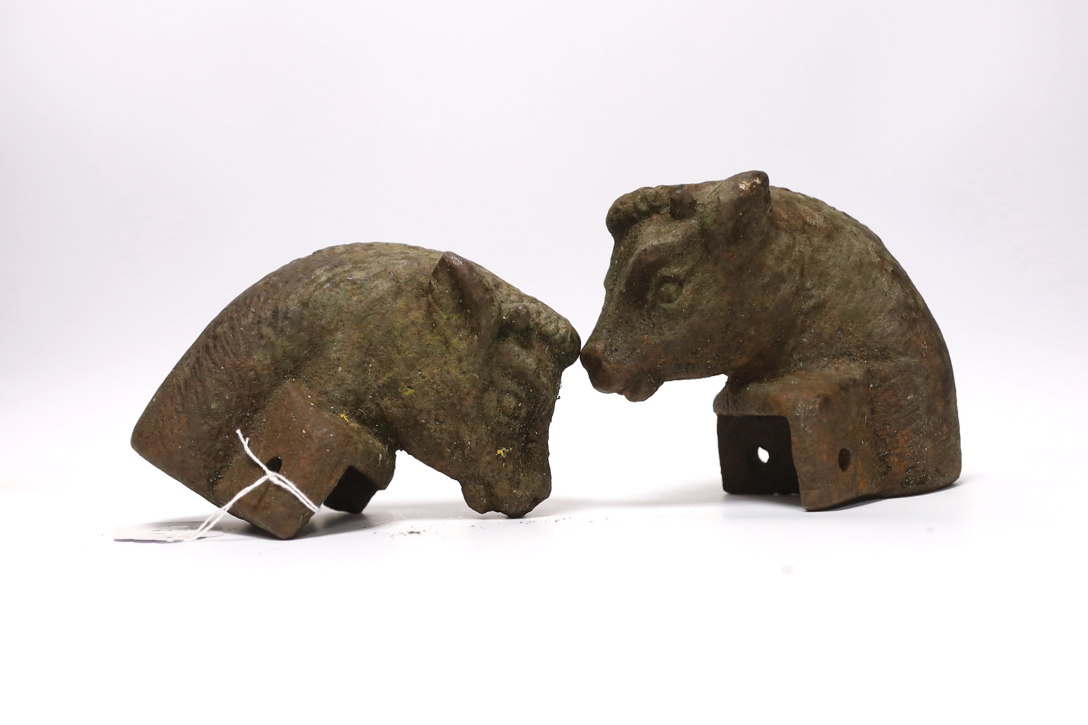 A pair of cast iron bull's head post finials, 13cm